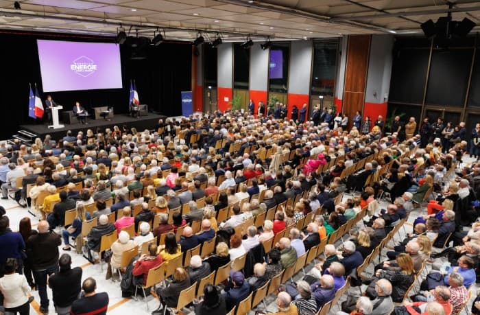 Vue aérienne d'une salle de conférence remplie de participants pendant un meeting de Nouvelle Énergie
