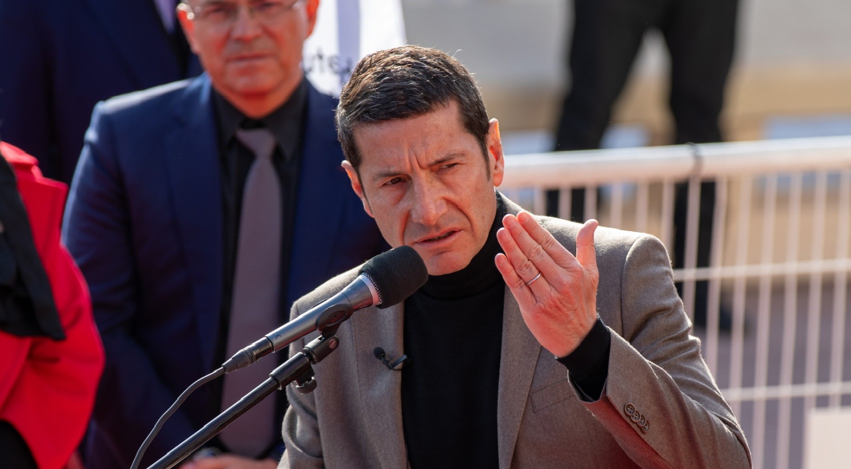 David Lisnard en costume gris, adressant un discours, devant un pupitre avec micro