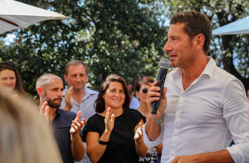 David Lisnard s'adressant à un groupe de personnes dans un cadre estival