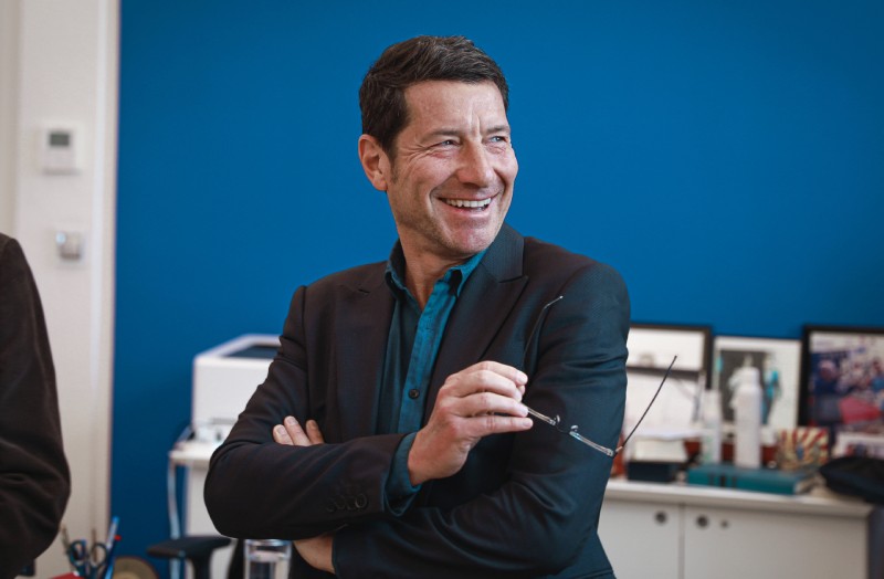 David Lisnard souriant, une paire de lunettes à la main