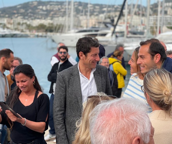 David Lisnard s'adressant à un groupe de personnes dans un cadre estival
